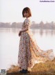 A woman standing in front of a body of water.