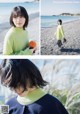 A woman in a green sweater standing on a beach.