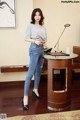 A woman standing in front of a desk in a room.